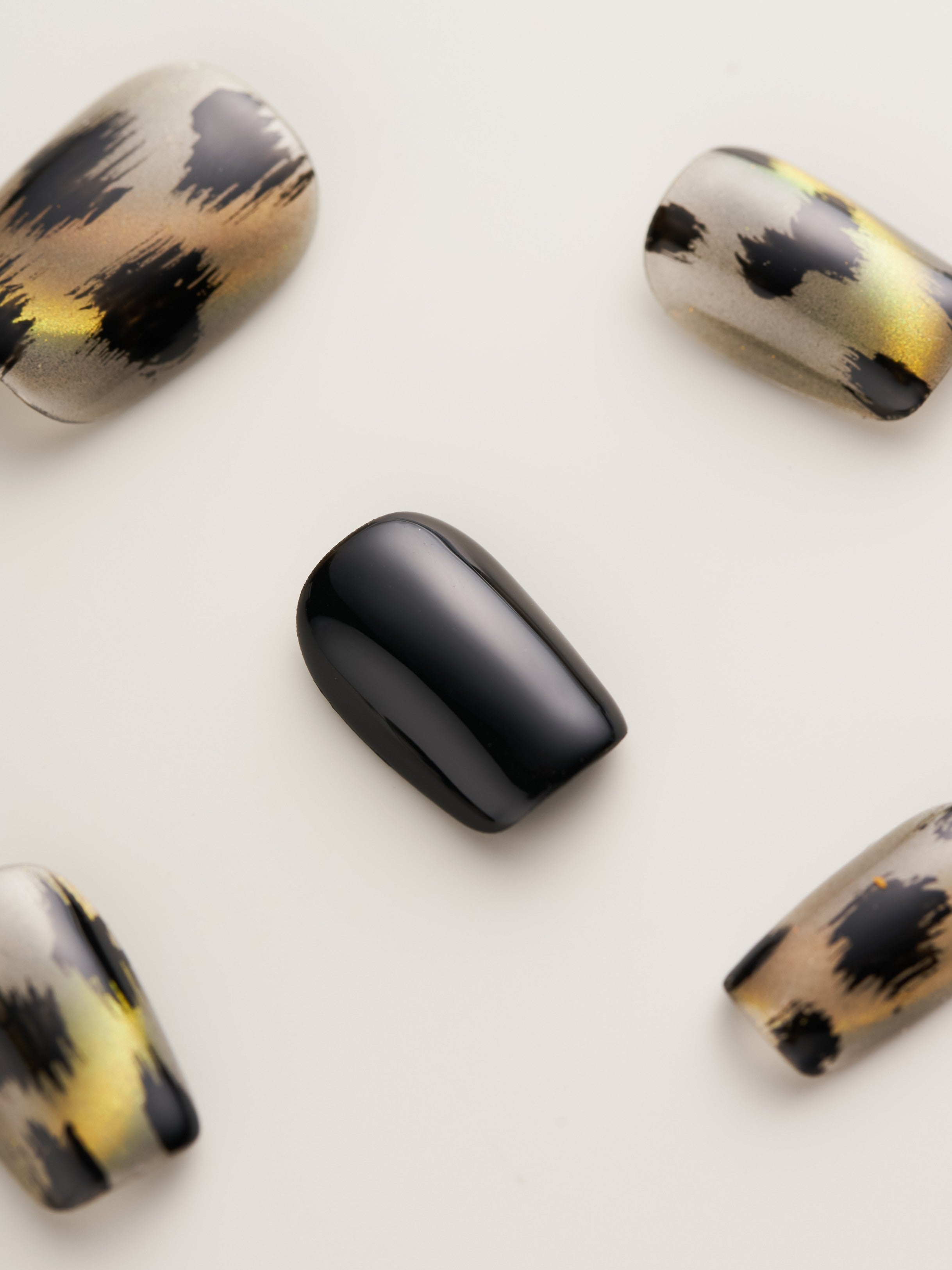 Artistic view of Leopard Print Glam Squoval Press-On Nails featuring a mix of leopard patterns and sleek black accents.