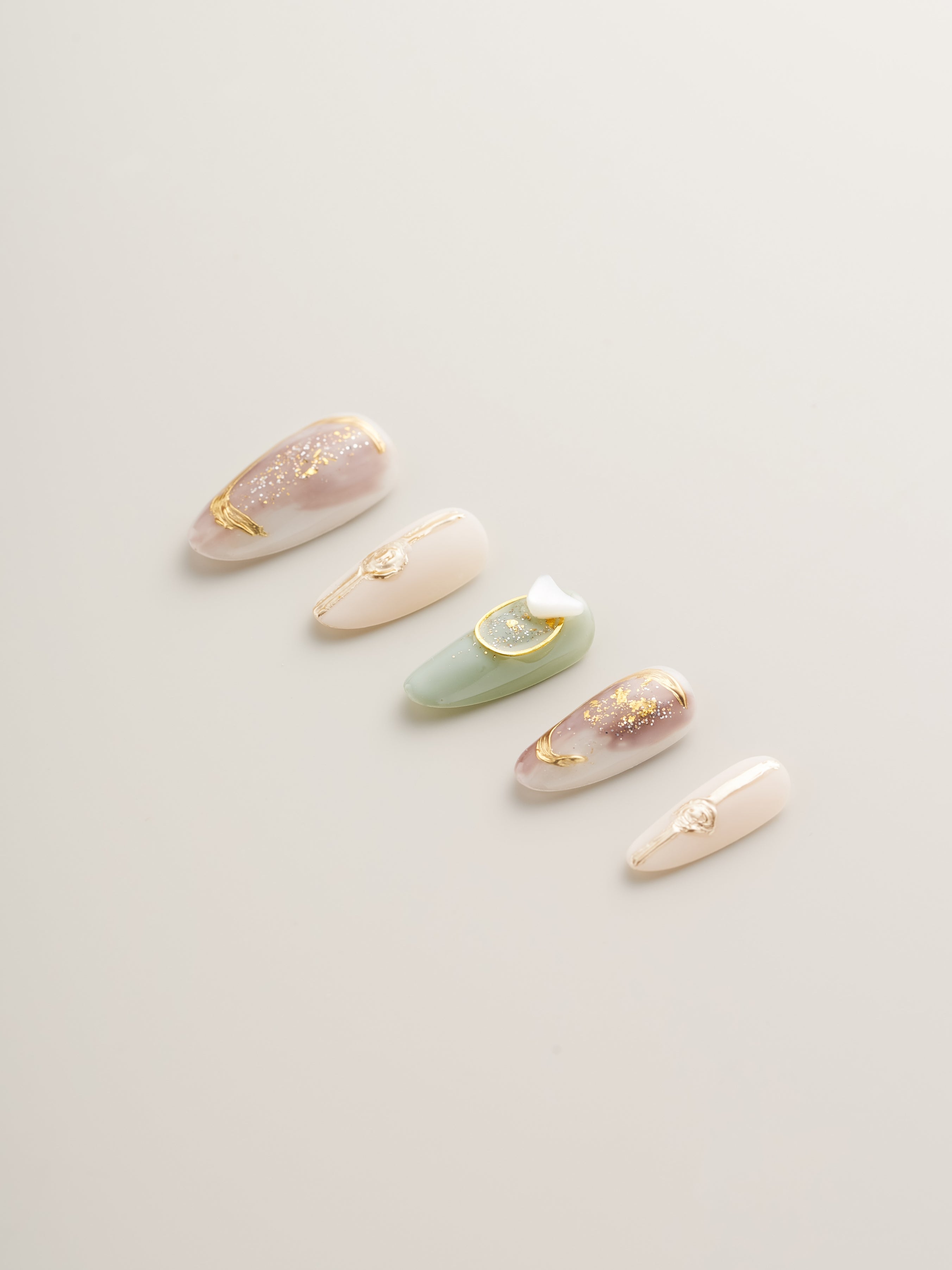 Stylish arrangement of Celestial Harmony Press-On Nails, highlighting the stunning gold embellishments and pastel colors for a chic look.