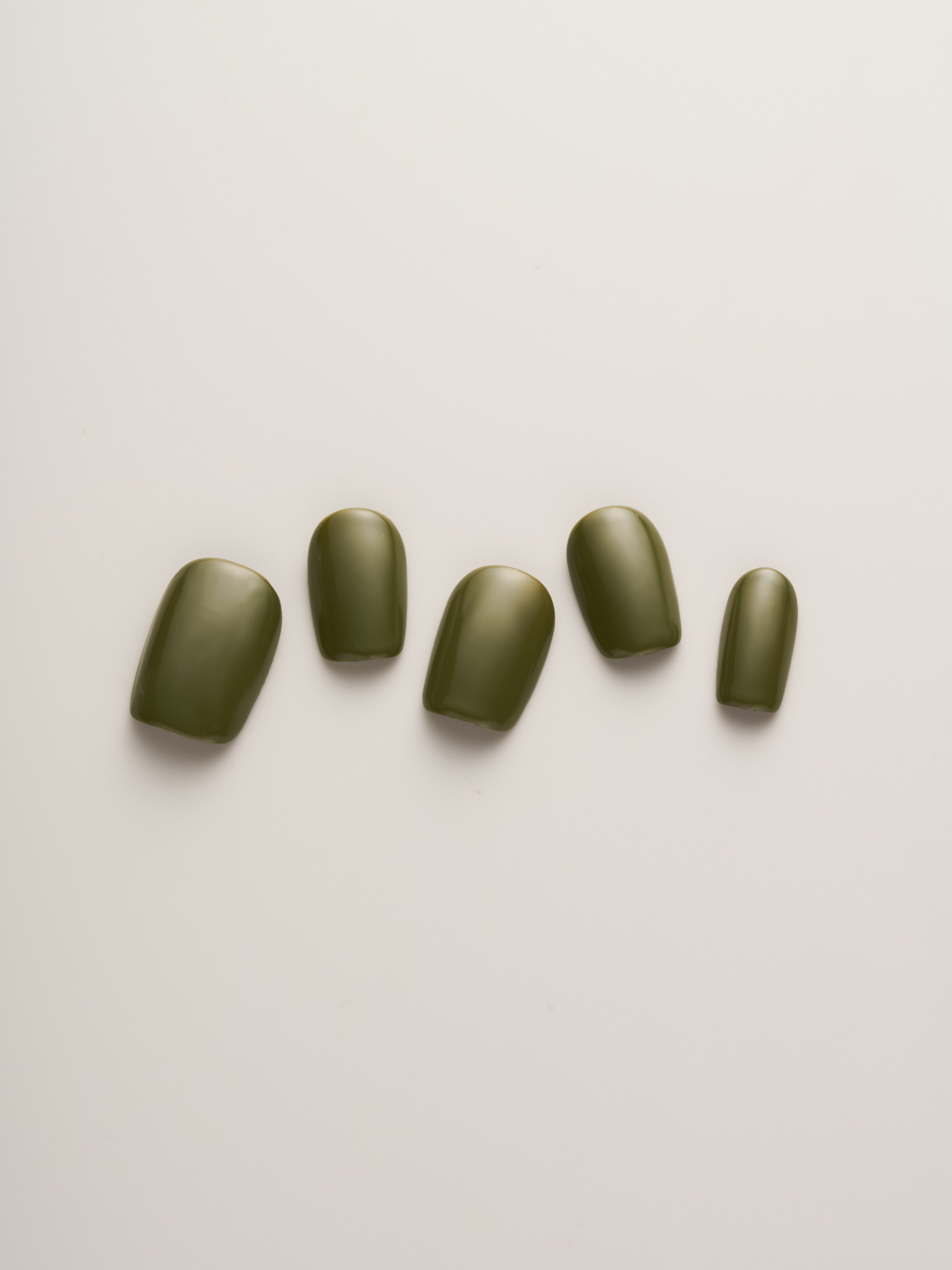 Minimalist Olive Green Squoval Press-On Nails in a stylish layout highlighting the elegant design and color.