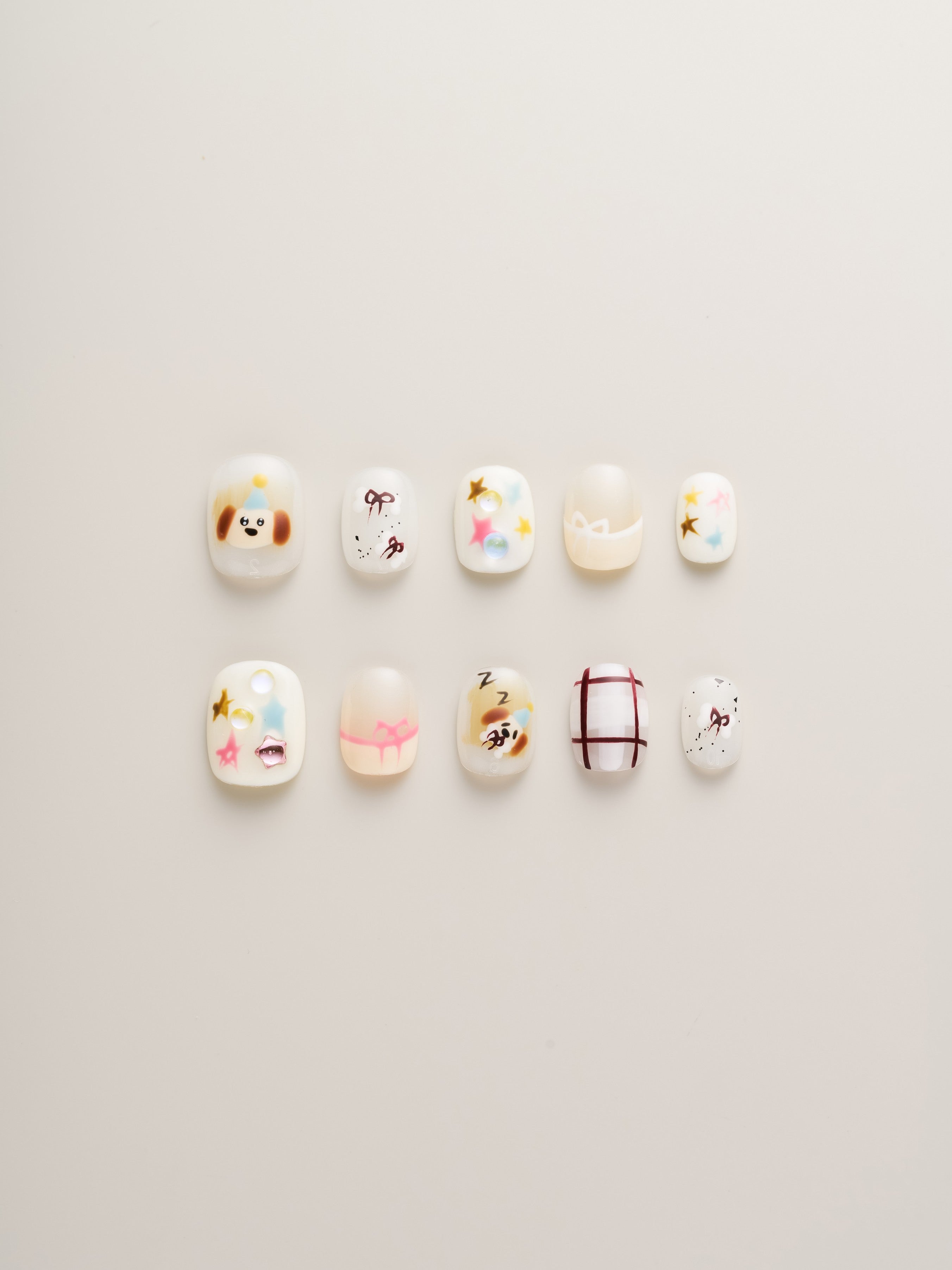 Whimsical Starry Night Squoval Press-On Nails showcasing a variety of playful designs, including colorful stars, a cute dog, and charming motifs.
