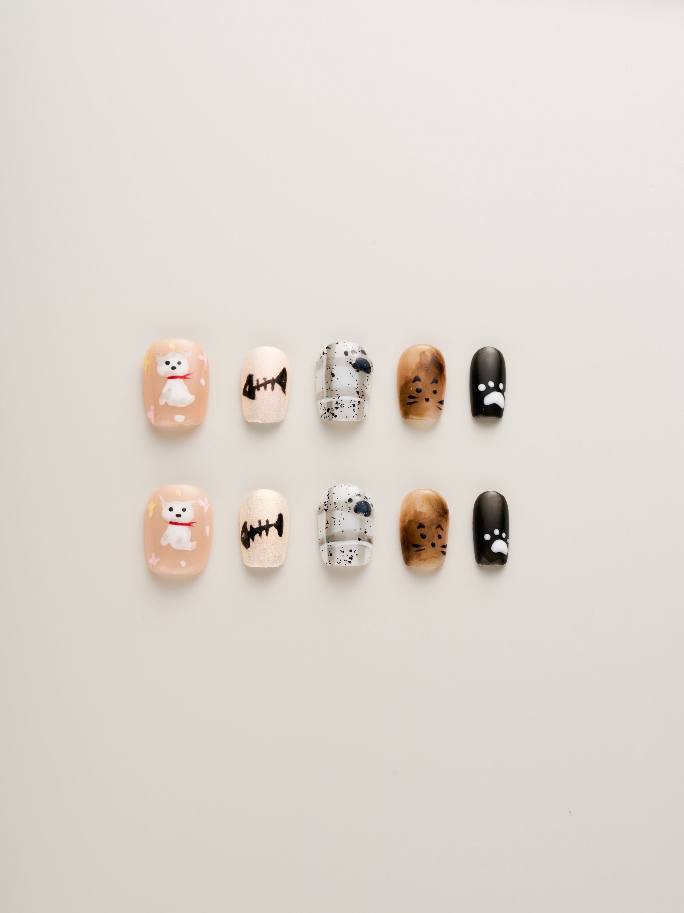 Playful Cat Lover’s Squoval Press-On Nails showcasing vibrant designs with hand-painted cats, fish bones, and paw prints.