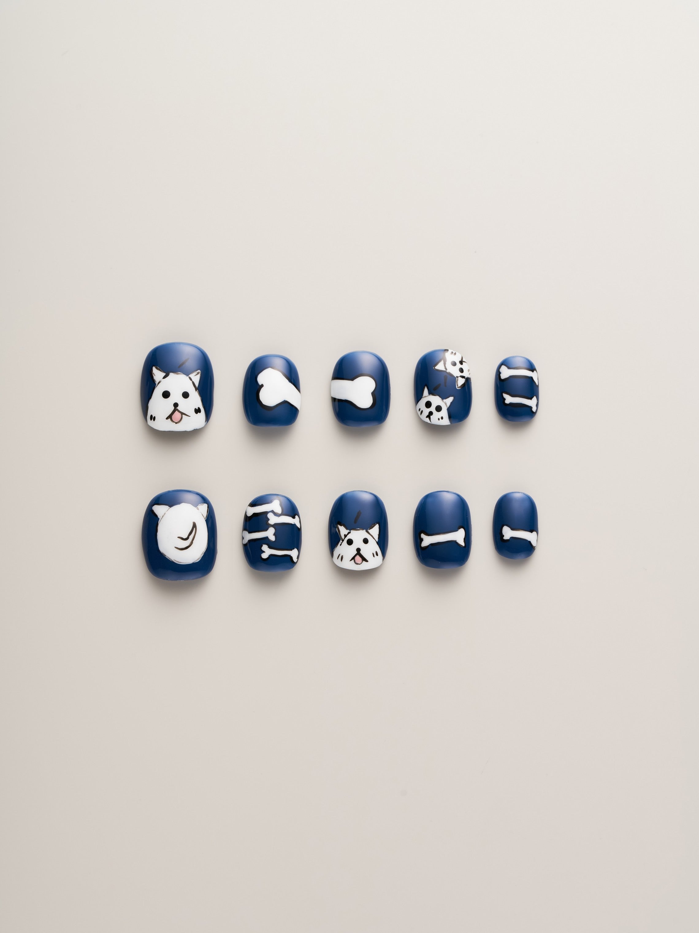 Bold Blue Dog Lover’s Squoval Press-On Nails featuring cute dog faces, bones, and paw prints on a vibrant blue background.