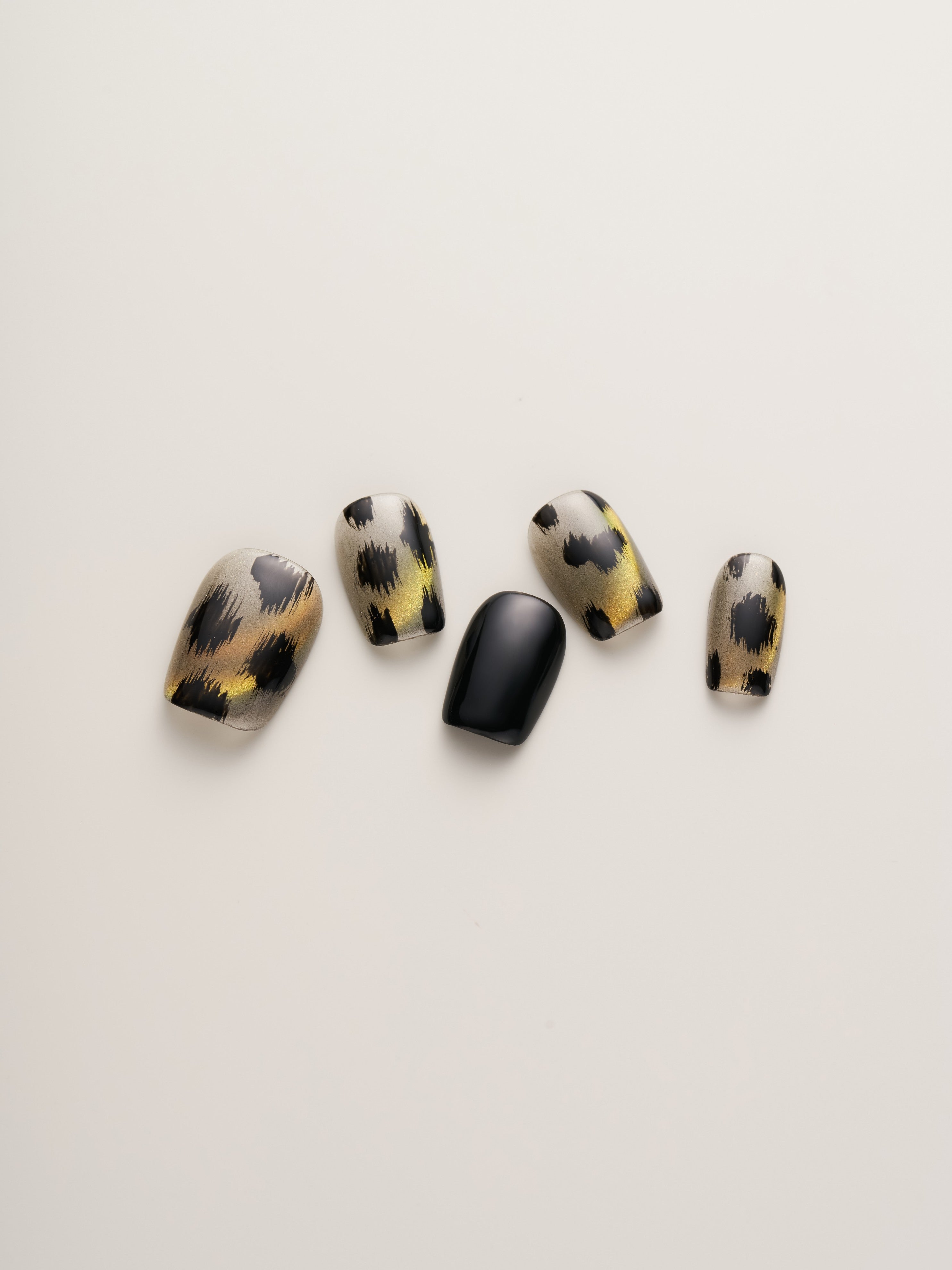 Close-up of Leopard Print Glam Squoval Press-On Nails displaying stylish animal print designs with golden metallic details.