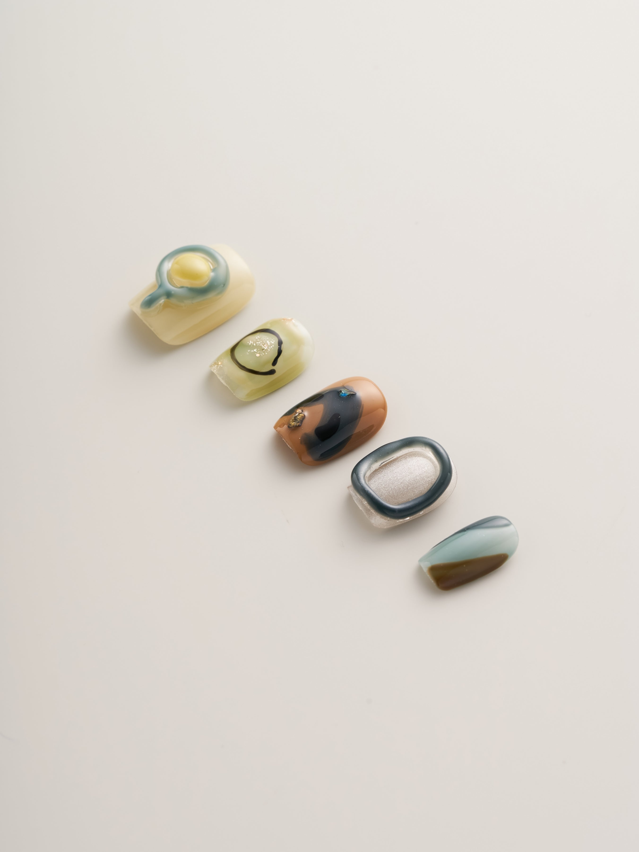 Display of Modern Abstract Squoval Press-On Nails highlighting intricate designs and finishes, ideal for a chic manicure.