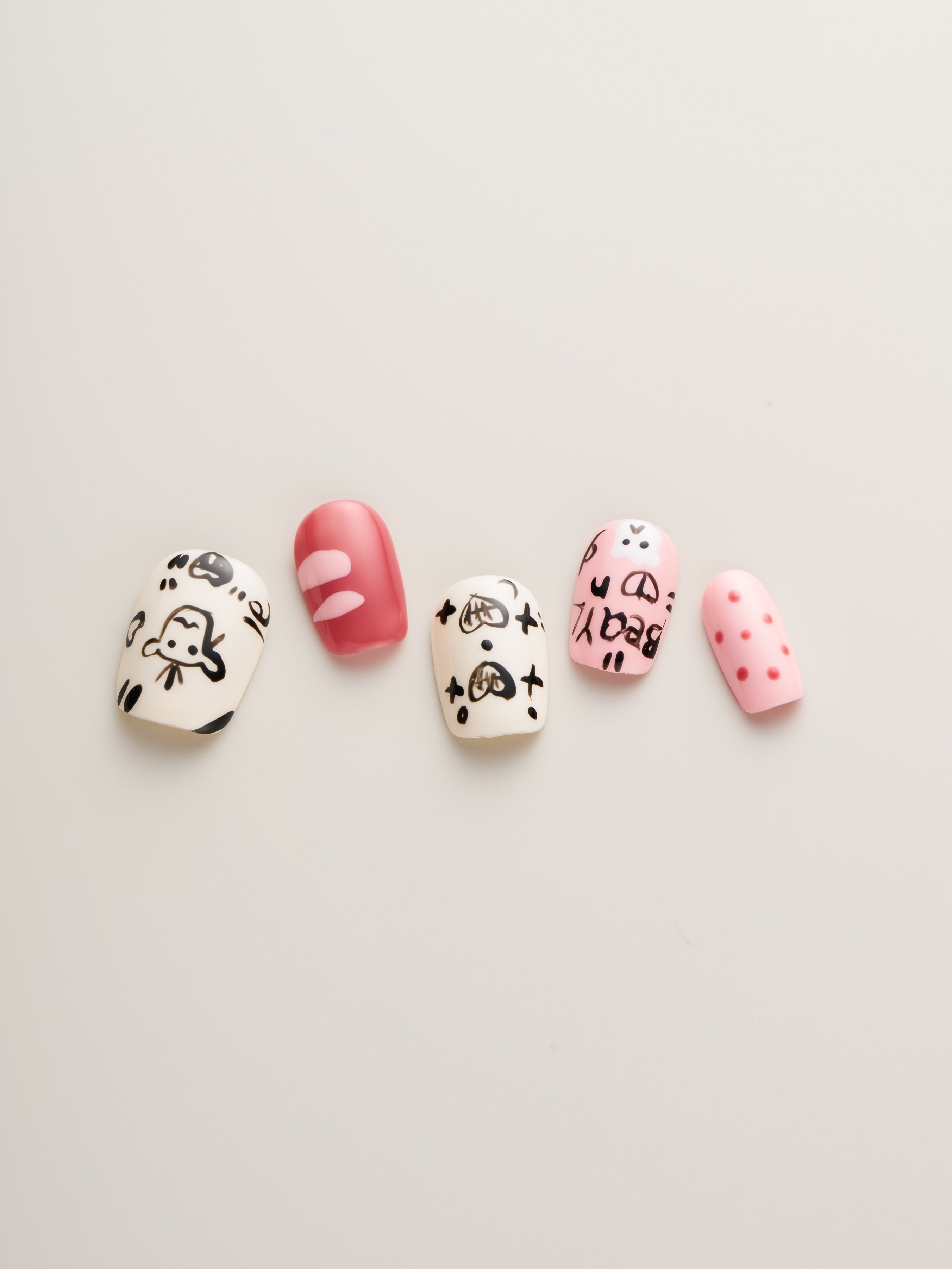 Close-up view of Playful Pink Cartoon Squoval Press-On Nails featuring cute designs including cartoon characters and a playful color palette, ideal for adding flair to your style.