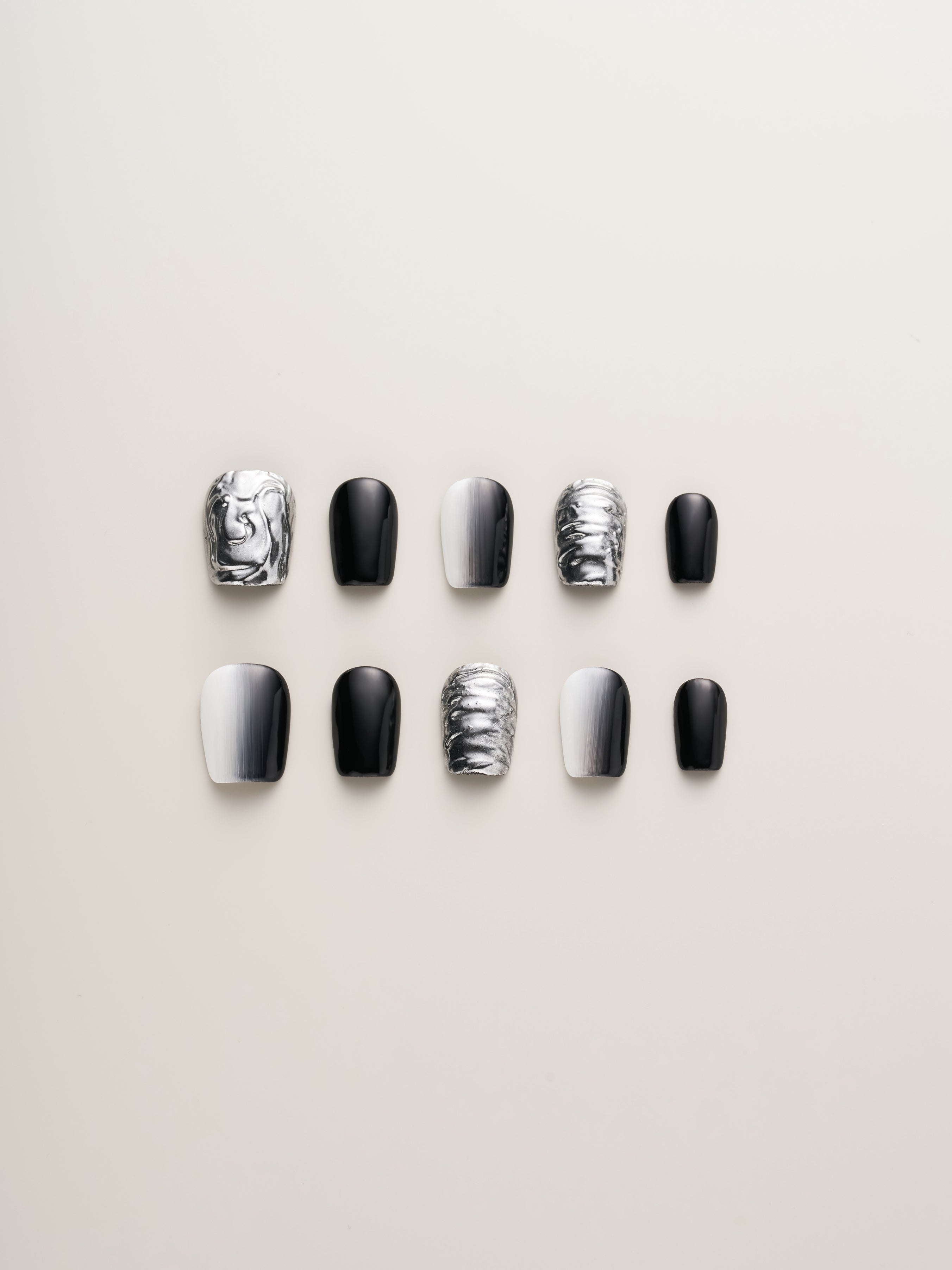 Stylish Monochrome Metal Press-On Nails in a variety of designs including glossy black, metallic silver, and gradient white. Perfect for a chic manicure.