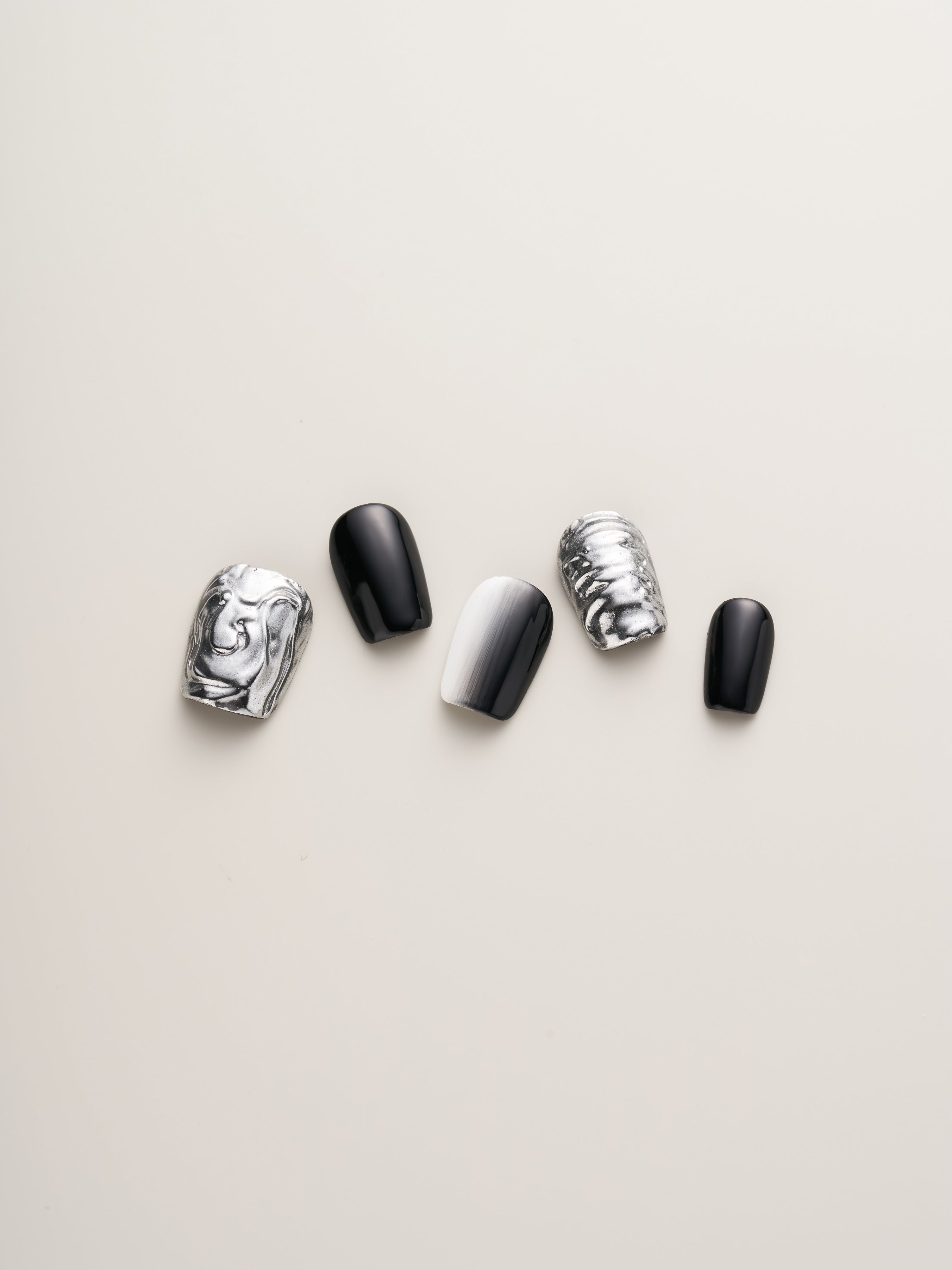 Close-up of Monochrome Metal Press-On Nails featuring bold black and white designs with metallic accents. Ideal for a fashionable look.