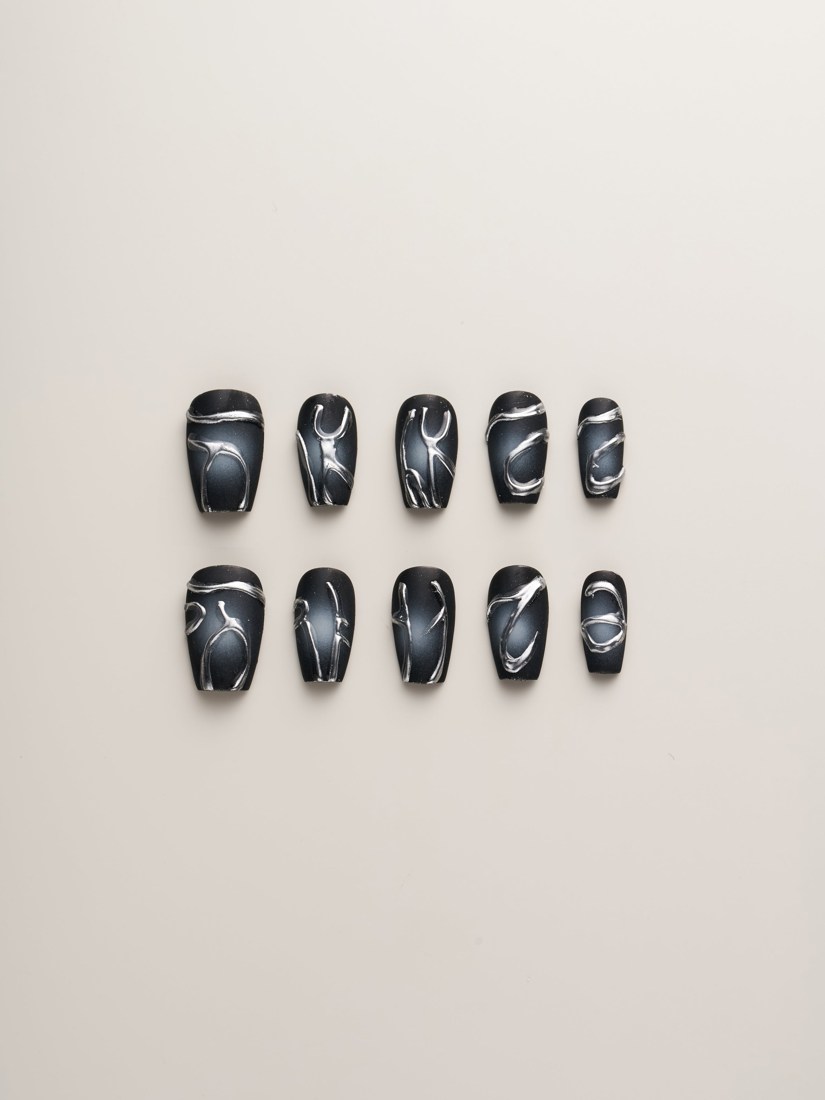 Midnight Noir – Press-On Nails set featuring a stylish arrangement of black nails with futuristic metallic silver abstract designs, perfect for a bold and edgy look.