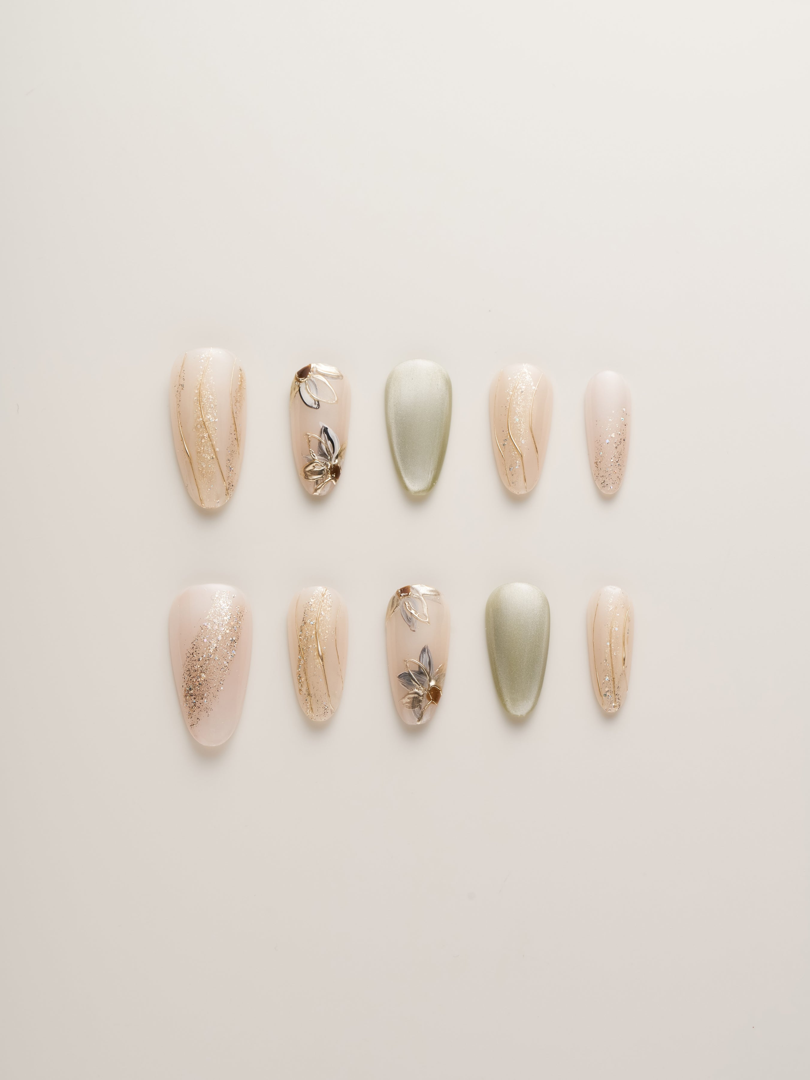 Golden Bloom – Nailè Ready-to-Wear Press-On Nails showcasing elegant nude nails with shimmering gold accents and floral designs.