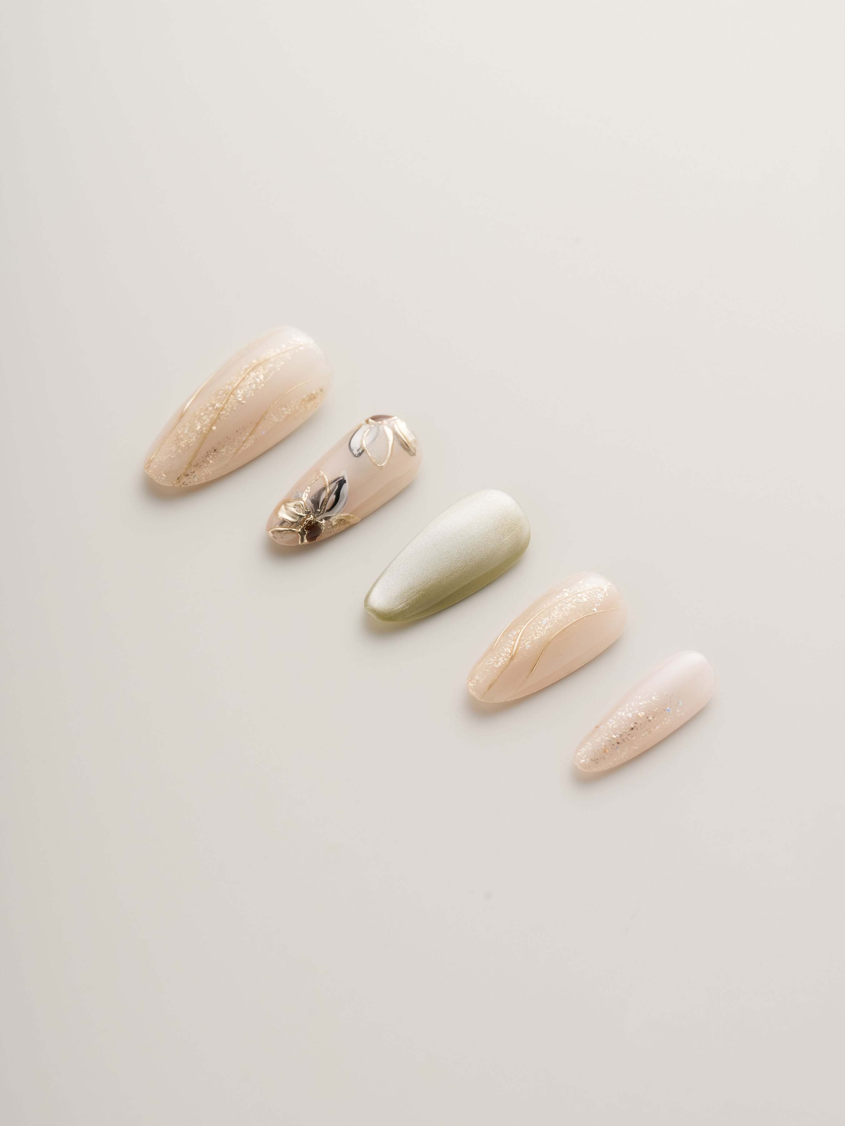 Golden Bloom – Nailè Ready-to-Wear Press-On Nails featuring a collection of beautiful press-on nails in a stylish arrangement with gold and floral details.