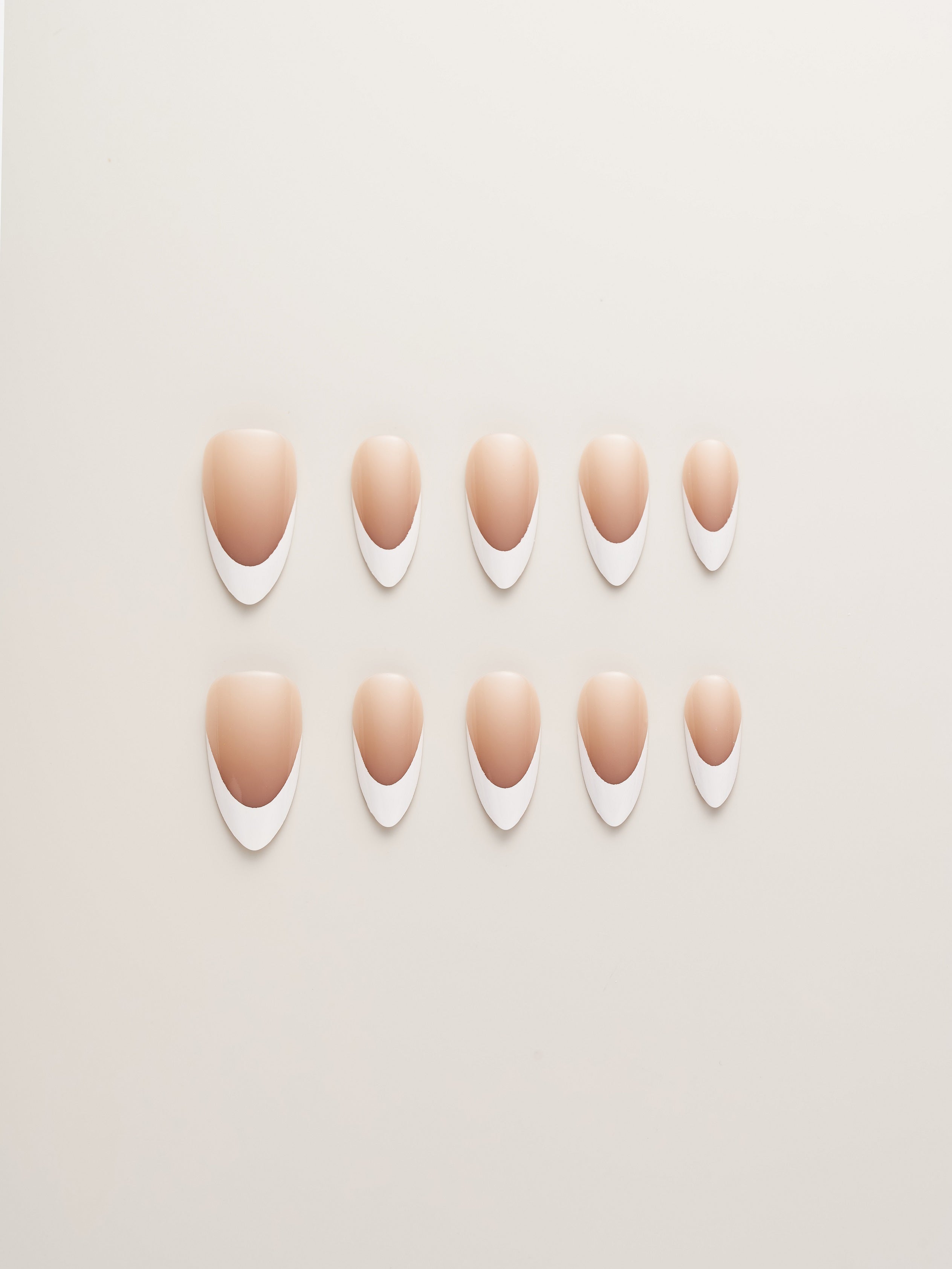 Classic Nude and White French Tip Almond Press-On Nails displayed in various sizes, perfect for achieving a stylish manicure at home.
