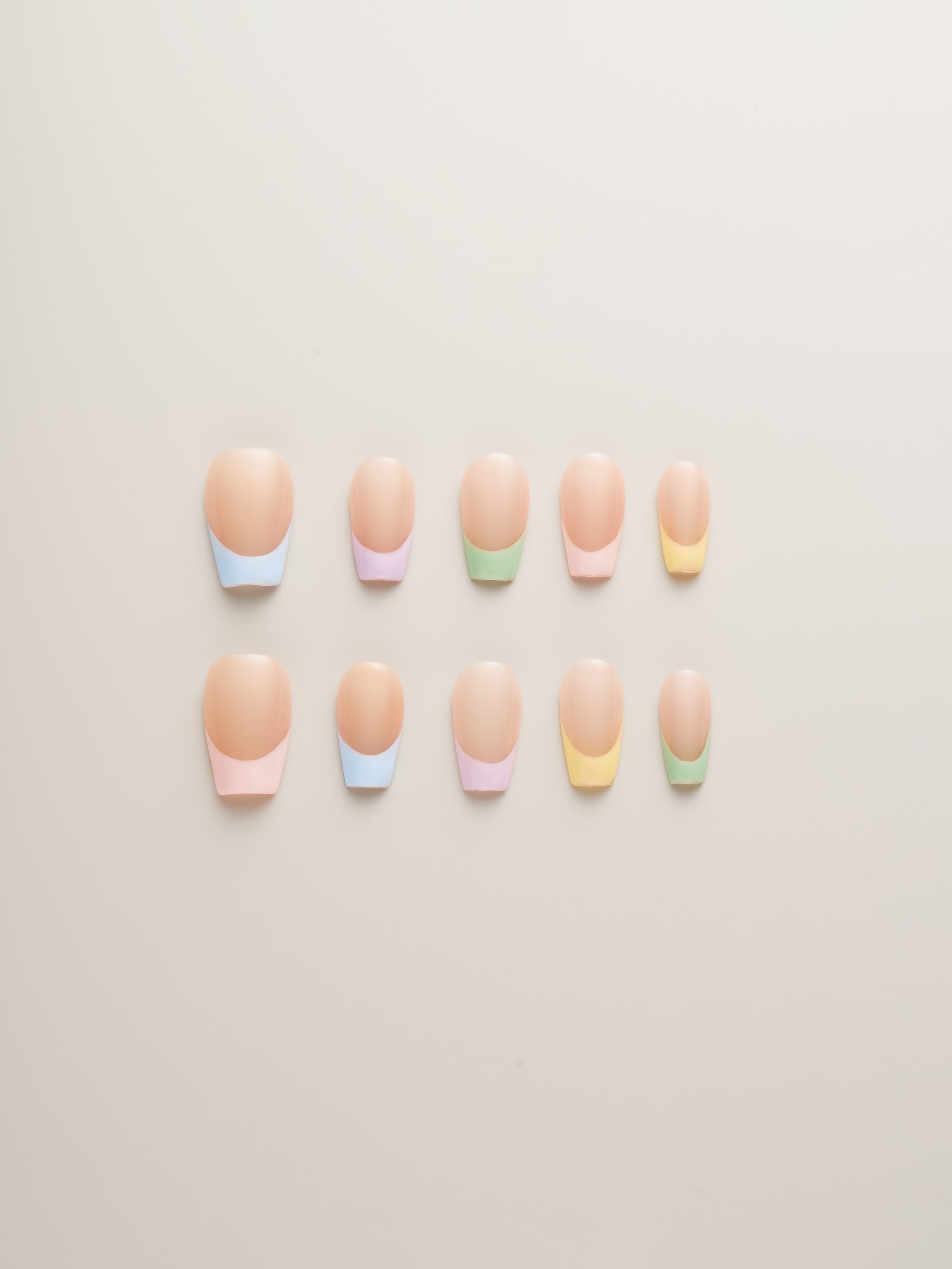 Pastel Chic French Tip Press-On Nails displayed in a variety of soft pastel colors on a neutral background. Perfect for a modern twist on classic nail designs.