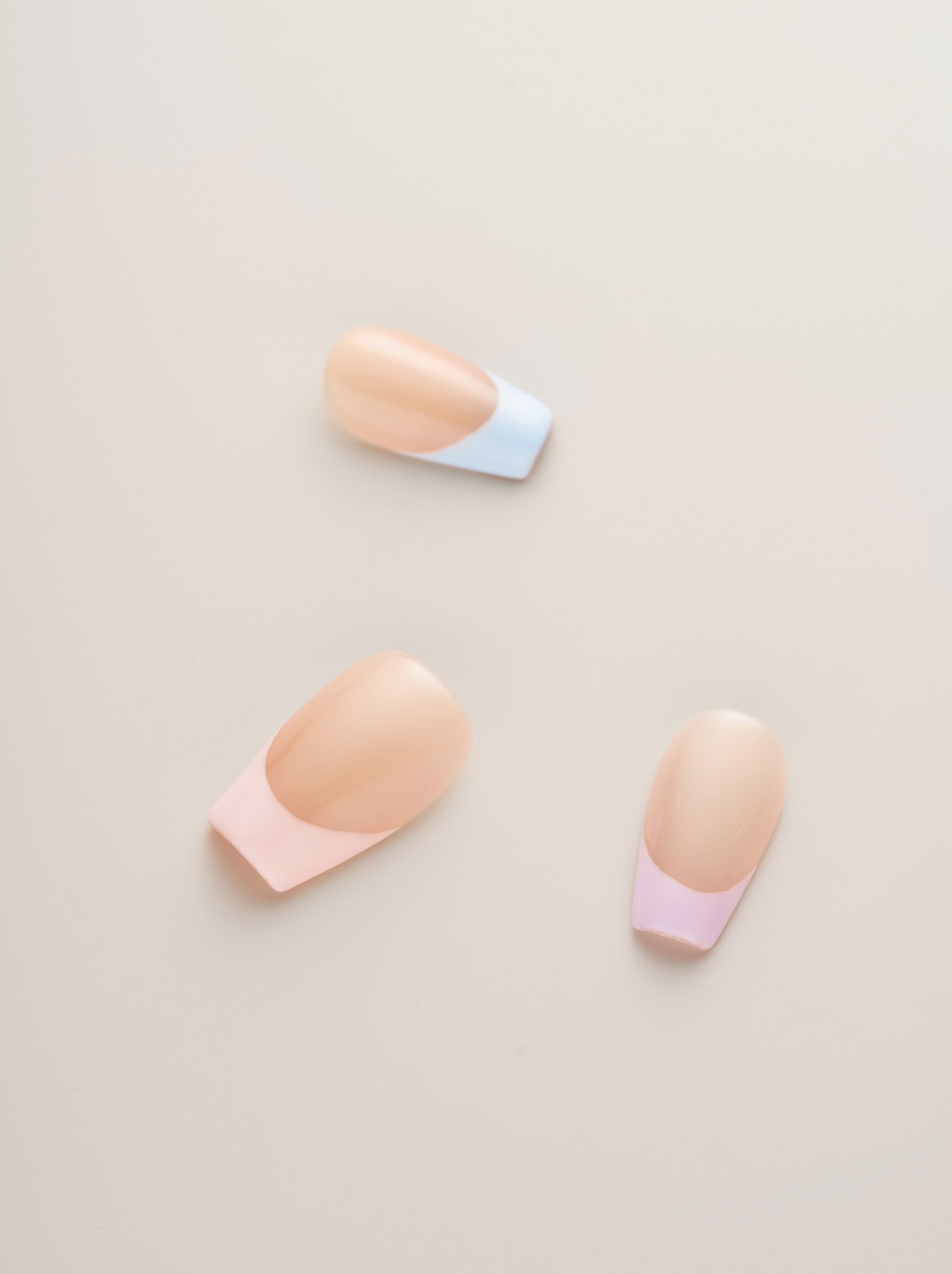 Three pastel tip press-on nails featuring a stylish design, highlighting the elegant blend of colors in the Pastel Chic French Tip collection.